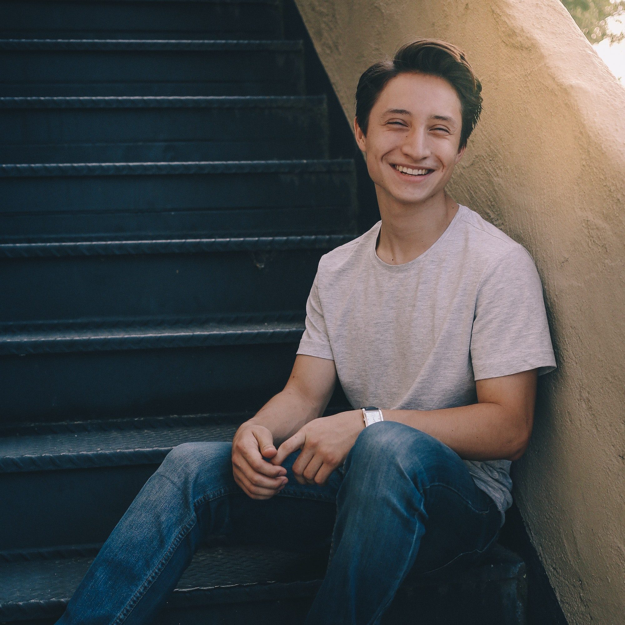 young-man-sitting-on-steps-and-laughing.jpg